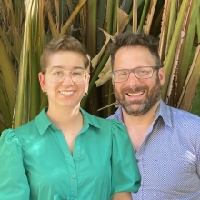 Two people smile at a camera